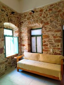 a living room with a couch and two windows at Loft House Syros in Ermoupoli