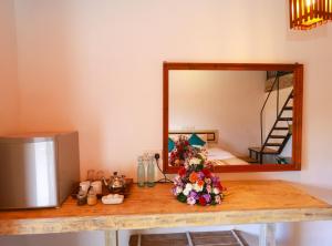 a table with a mirror and flowers on it at Amber Reach Cottages in Ella +9 photos