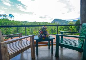 a balcony with two benches and a table with flowers on it at Amber Reach Cottages in Ella