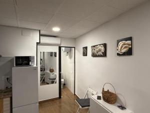 a white room with a refrigerator and a bathroom at Loft Ohanes in Ohanes