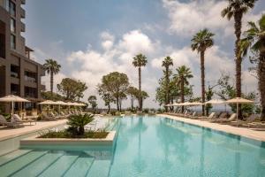 a pool at a hotel with chairs and palm trees at Keyla Hotel & Beach - Adult Only in Antalya