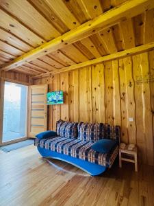 a couch in a room with a wooden wall at Stripeikių Bitė in Varniškės I