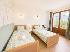 two beds in a room with a window at Le Lac Bleu - Sevrier in Sévrier