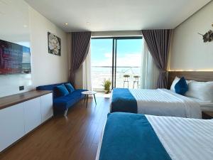 a hotel room with two beds and a couch at Apec mandala new Phú yên in Tuy Hoa +112 photos