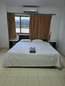 a bedroom with a bed with a pair of slippers on it at The Royal Pattaya Cantina Near Walking Steer in Pattaya South +5 photos