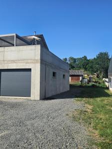 a building with a garage on a gravel road at Appartement le Crozatier in Saint-Georges