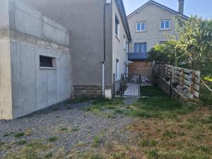 a house with a fence next to a building at Appartement le Crozatier in Saint-Georges +4 photos