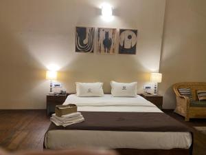 ein Hotelzimmer mit einem großen Bett und zwei Lampen in der Unterkunft Colonial 44 in Kohīma