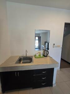 a kitchen counter with a sink and a mirror at The Royal Pattaya Cantina Near Walking Steer in Pattaya South
