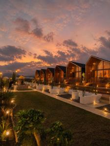 a row of lodges with a sunset in the background at Glamour camping bedugul in Bedugul