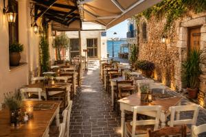 a restaurant with tables and chairs and the ocean at Enetiko Rooms in Chania