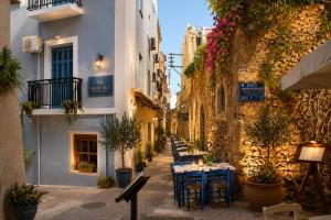 a street with tables and chairs in an alley at Enetiko Rooms in Chania