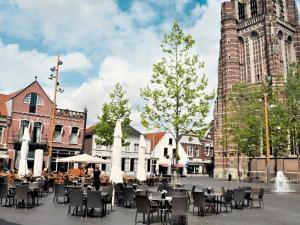 a group of tables and chairs in front of a building at A-Hotel Oosterhout in Oosterhout