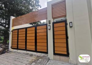 a pair of wooden garage doors on a house at Newly Built Private Villa with Pool in Cainta in Cainta
