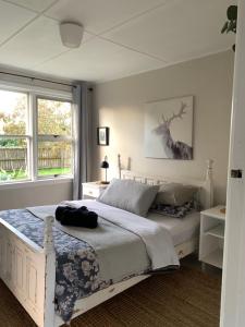 a bedroom with a bed and a deer picture on the wall at Cooper's Cottage in Nelson