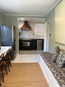 a living room with a couch and a kitchen at Cooper's Cottage in Nelson +28 photos