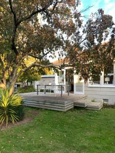 a patio with a table and a tree at Cooper's Cottage in Nelson