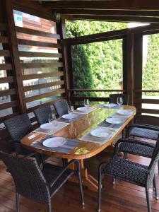 a wooden table with chairs on a porch at Lake House in Svityazʼ +10 photos