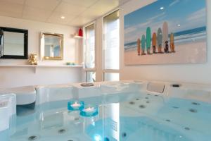 a large tub in a room with a beach at Hôtel Omnubo Collection in Les Épesses +59 photos