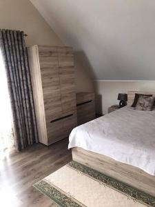 a bedroom with a large bed and a dresser at Lake House in Svityazʼ