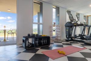 a room with a gym with a treadmill at Hôtel Omnubo Collection in Les Épesses