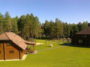 a log cabin and a park with a playground at Sodyba Tundra in Nastazavas