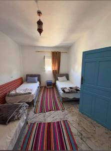 a room with two beds and a blue door at dar fatma matmata in Matmata +24 photos