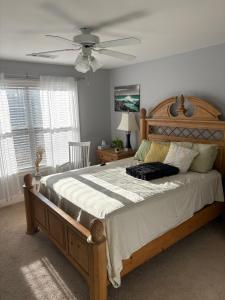 a bedroom with a wooden bed and a ceiling fan at Karibuni Braselton in Braselton