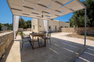 eine Terrasse mit Tisch und Stühlen unter einem weißen Sonnensegel in der Unterkunft Elichrysos house in Kagkátika + 9 Fotos