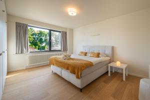 a bedroom with a bed and a window at Zenzalea Oostkamp in Oostkamp