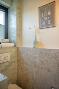 a bathroom with a vase sitting on a tile wall at Zenzalea Oostkamp in Oostkamp +48 photos