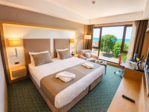 a hotel room with a large bed and a large window at Blue Sea Hotel in Trabzon