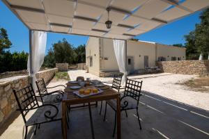 eine Terrasse mit Tisch und Stühlen und ein Gebäude in der Unterkunft Elichrysos house in Kagkátika