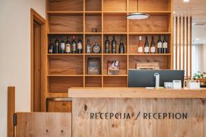 a bar with a counter with bottles of wine at Trivrh Outdoor Hotel in Žirovnica
