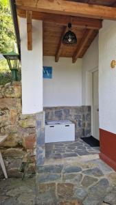 an outdoor kitchen with a stone wall and a wooden ceiling at La casina de Pili in Villaviciosa