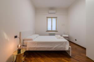a white bedroom with a bed and a window at Effealatapartments - Appartamento del Duca in Senigallia