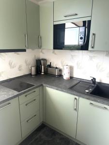a kitchen with white cabinets and a microwave at Wolkenparadies in Altenau