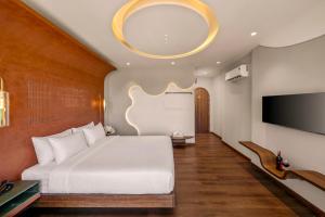 a bedroom with a large bed and a tv at Vista Del Sol Hotel in Danang