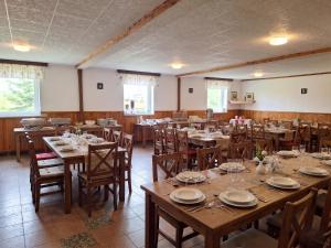 a dining room with wooden tables and chairs with plates at Relaxační centrum Orion in Roudná