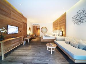 a living room with a couch and a tv at AKIRA Lipe Resort in Ko Lipe