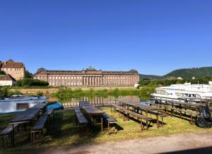 a group of benches next to a river with a boat at triDOMESFRANCE in Saverne