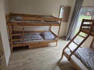 two bunk beds in a room with a window at Relaxační centrum Orion in Roudná