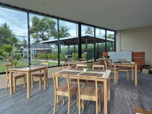 a restaurant with tables and chairs and large windows at The Samui Villa Retreat in Ban Bang Po