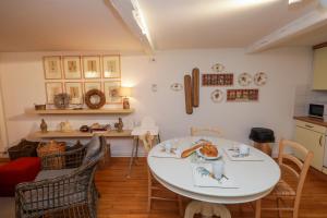 une salle à manger avec une table et des chaises blanches dans l'établissement ColmarAppart Vauban, à Colmar