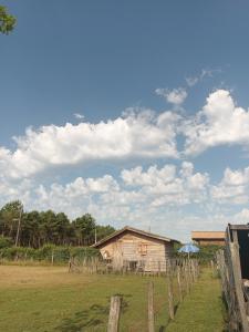 a barn in a field next to a fence at Gîte - La Ferme à la Plage in Le Porge