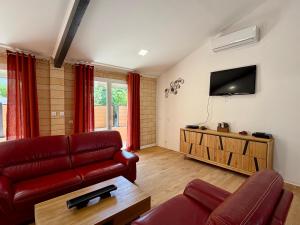 a living room with a couch and a flat screen tv at Résidence les Caraibes in Sérignan