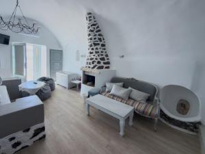a living room with a couch and a fireplace at Diamond on the cliff Hotel&Suites Imerovigli in Imerovigli