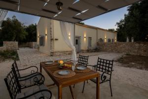 eine Terrasse mit Tisch und Stühlen und ein Gebäude in der Unterkunft Elichrysos house in Kagkátika