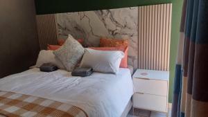 a bedroom with a bed with white sheets and pillows at Mangena Legacy Guesthouse in Polokwane