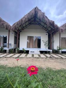 a red flower in front of a house at Ananda Uthaan in Sreemangal
